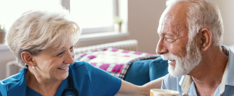 A senior man smiles at a nurse | Presbyterian Home and Retirement Community Quitman